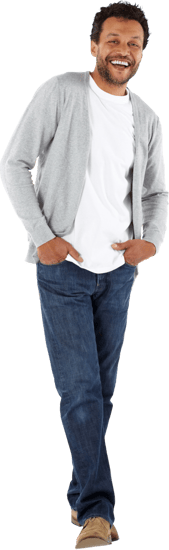 A man smiling and standing with his hands in his pocketes