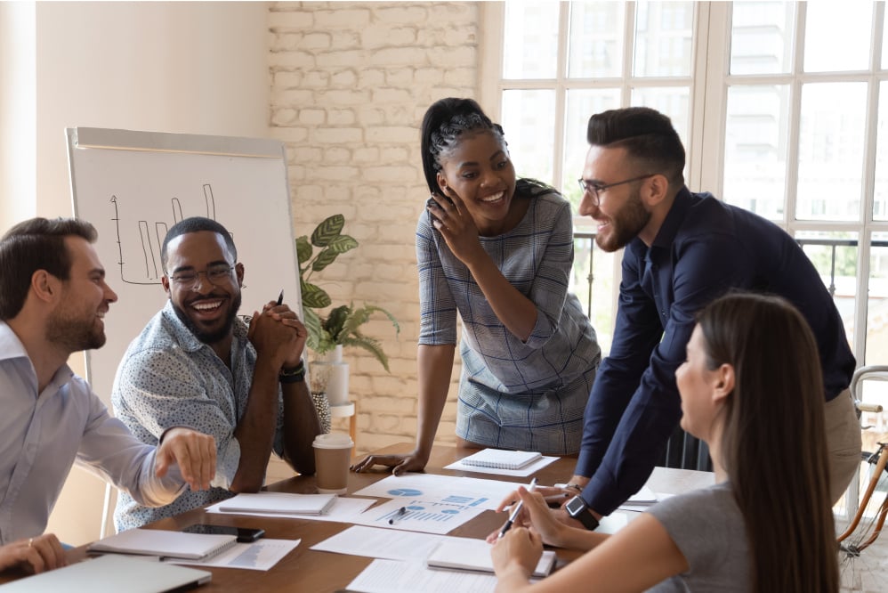 5 employees discussing over a table